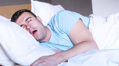 Sabbernder Mann in frischer Bettwäsche