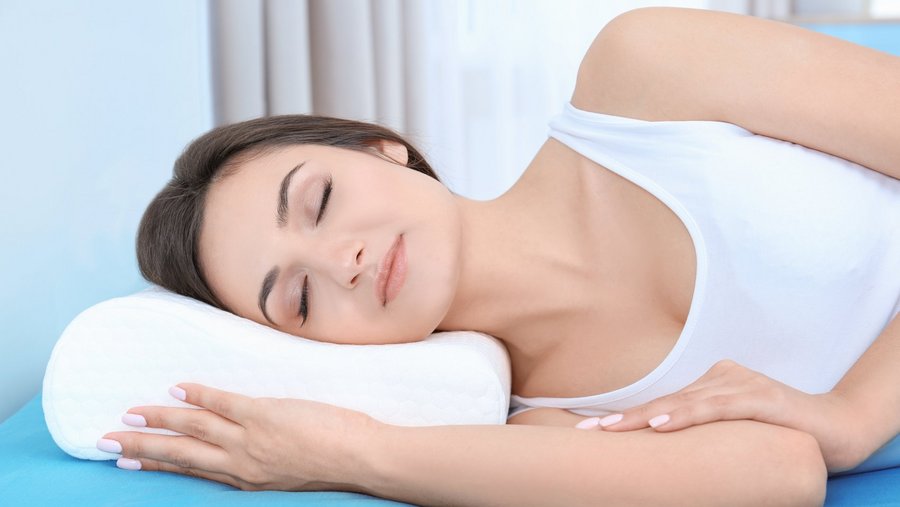 Person entspannt schlafend mit Sleezzz Nackenstützkissen, das ergonomisch den Nacken stützt und für eine gesunde Schlafposition sorgt